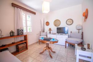 a living room with a couch and a table at Dora's Beach Cottages in Planos