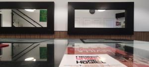 two framed pictures on a glass table in a room at New Samay Hostel in Seville