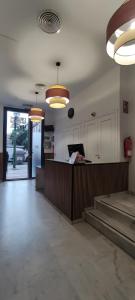 a lobby with stairs and pendant lights in a building at New Samay Hostel in Seville