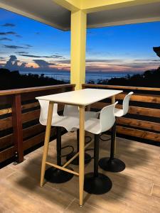 a table and chairs on a balcony with a view at Honey Lodge in Punaauia
