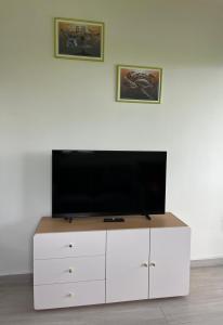 a flat screen tv sitting on top of a white entertainment center at Honey Lodge in Punaauia