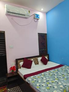a bedroom with a bed and a air conditioner on the wall at Riskla hotel Near-Ram Mandir 700M in Ayodhya +1 photo