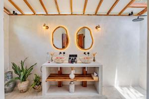 a bathroom with two mirrors on the wall at Bale Sampan Boutique Bungalows in Gili Trawangan