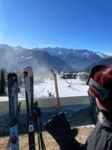 a person holding up a group of skis and ski poles at Chambre double privée in Martigny-Ville +2 photos