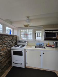 a kitchen with a white stove and a sink at Dalton's Deed in Roxburgh