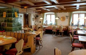 a restaurant with wooden tables and chairs and windows at Historisches Genusshotel Löwen in Schopfheim