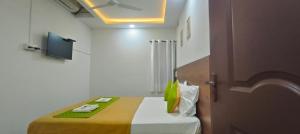 a small room with a bed with a yellow blanket at Hotel Royal Green Inn in Chennai