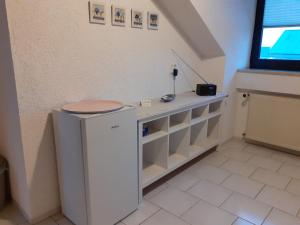 a room with a small white refrigerator and a window at Gästewohnung in Parkstetten bei Straubing in Parkstetten