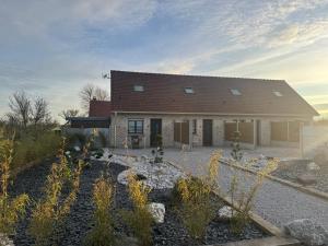 a house with a landscaping in front of it at Le repaire 3 in Saint-Omer-Capelle
