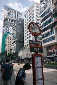 a woman standing next to a no parking sign on a street at 枫枫枫 in Hong Kong