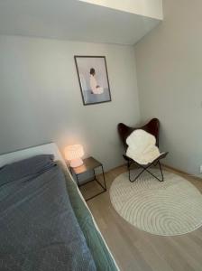 a bedroom with a bed and a chair and a rug at Cozy private room centrally in Jessheim in Jessheim
