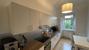 a kitchen with white cabinets and a table and a window at Junior Suite Apartment Eleven in Graz