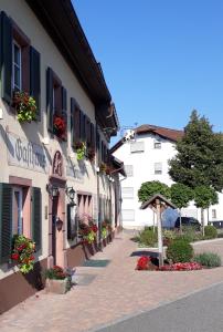 a building with flowers on the side of a street at Historisches Genusshotel Löwen in Schopfheim