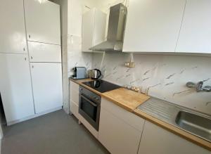 a kitchen with white cabinets and a stove top oven at Giulia Home appartamento per 6 persone in Monfalcone