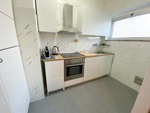 a small kitchen with a stove and a sink at Giulia Home appartamento per 6 persone in Monfalcone +18 photos