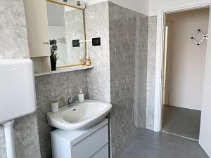 a white bathroom with a sink and a mirror at Giulia Home appartamento per 6 persone in Monfalcone