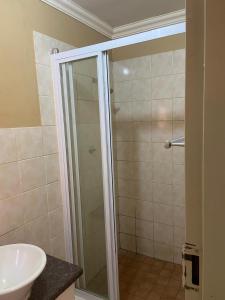 a bathroom with a shower and a sink at Matte Guest House in Potchefstroom +21 photos