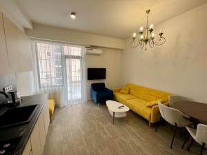 a living room with a yellow couch and a table at Verinn Apart Hotel in Dilijan