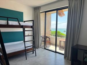 a bedroom with bunk beds and a balcony with the ocean at Linará in Hikkaduwa
