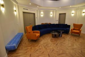 a living room with a blue couch and orange chairs at Resort Villa Las Palmeras in Roquetas de Mar +108 photos