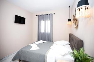 a bedroom with a bed and a television in it at GreKa apartments in Kalives Poligirou