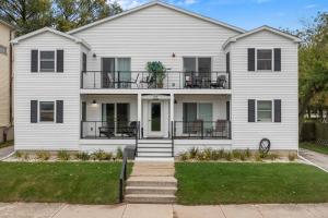 a white house with a porch and balcony at Beachside Condo w Stunning Lake Views in Sheboygan