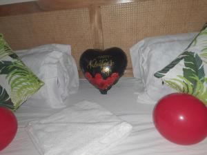 a bed with a heart shaped pillow with a happy birthday sign at Aqua Garden Building in Nyali