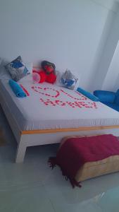 a bed with red rose petals on it at Aqua Garden Building in Nyali