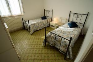 a bedroom with two beds and a window at Trilocale centrale e a due passi dal mare con posto auto privato in Marcelli