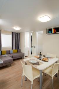 a dining room and living room with a table and chairs at Camping Parisi in Baveno