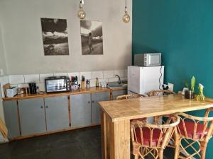 a kitchen with a wooden table and a refrigerator at Geckos Rest Southbroom in Southbroom