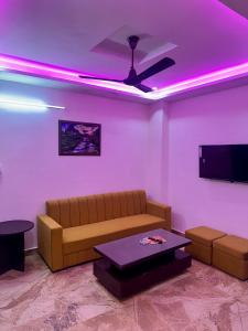 a living room with a couch and purple lights at Cabana suites in Rishīkesh