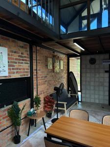 a patio with a table and chairs and a brick wall at Tiny House in Kuala Terengganu
