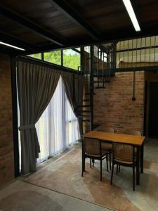 a dining room with a wooden table and chairs at Tiny House in Kuala Terengganu
