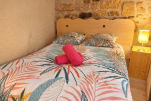 a bed with two red pillows on it with at Le Nid Comtois in Vic-le-Comte