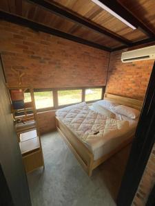 a bedroom with a bed in a brick wall at Tiny House in Kuala Terengganu