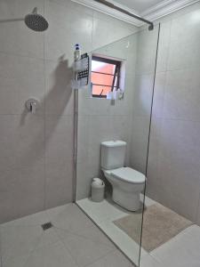 a bathroom with a toilet and a shower at Nomland in Walvis Bay +7 photos