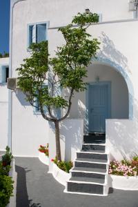 a white house with a blue door and stairs at Blu Rooms Santorini in Akrotiri
