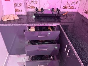 a kitchen with purple drawers and a counter top at Cabana suites in Rishīkesh