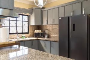 a kitchen with stainless steel appliances and a refrigerator at Casa familiar con piscina y cerca de la playa in La Belleza
