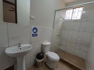 a bathroom with a toilet and a sink at Villa Gabriel Hotel in Piura
