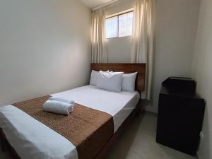 a bedroom with a bed with a pillow on it at Villa Gabriel Hotel in Piura