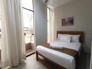 a bedroom with a bed and a large window at Villa Gabriel Hotel in Piura