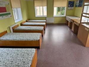 una fila di letti in una sala d'attesa di Nichi camp a Dekšāre