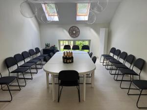 una sala conferenze con tavolo e sedie bianche di Nichi camp a Dekšāre