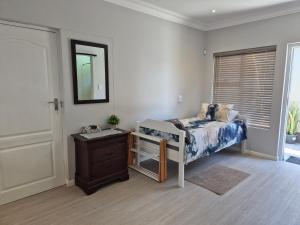 a bedroom with a bed and a dresser and a mirror at Nomland in Walvis Bay