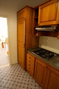 a kitchen with wooden cabinets and a stove top oven at Trilocale centrale e a due passi dal mare con posto auto privato in Marcelli