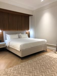 a bedroom with a large white bed and a rug at Symphony Boutique in Tashkent