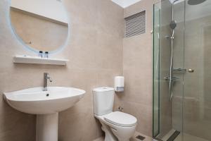 a bathroom with a sink and a toilet and a mirror at Kokkari Beach Hotel in Kokkari +48 photos