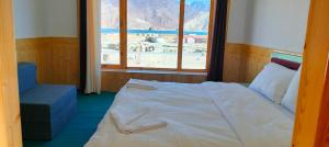 a bedroom with a bed and a window with a view at Vajra Inn Pangong in Meruk